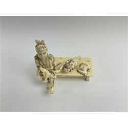 Japanese Meiji period ivory figure of a man with boy on a bench H10cm.