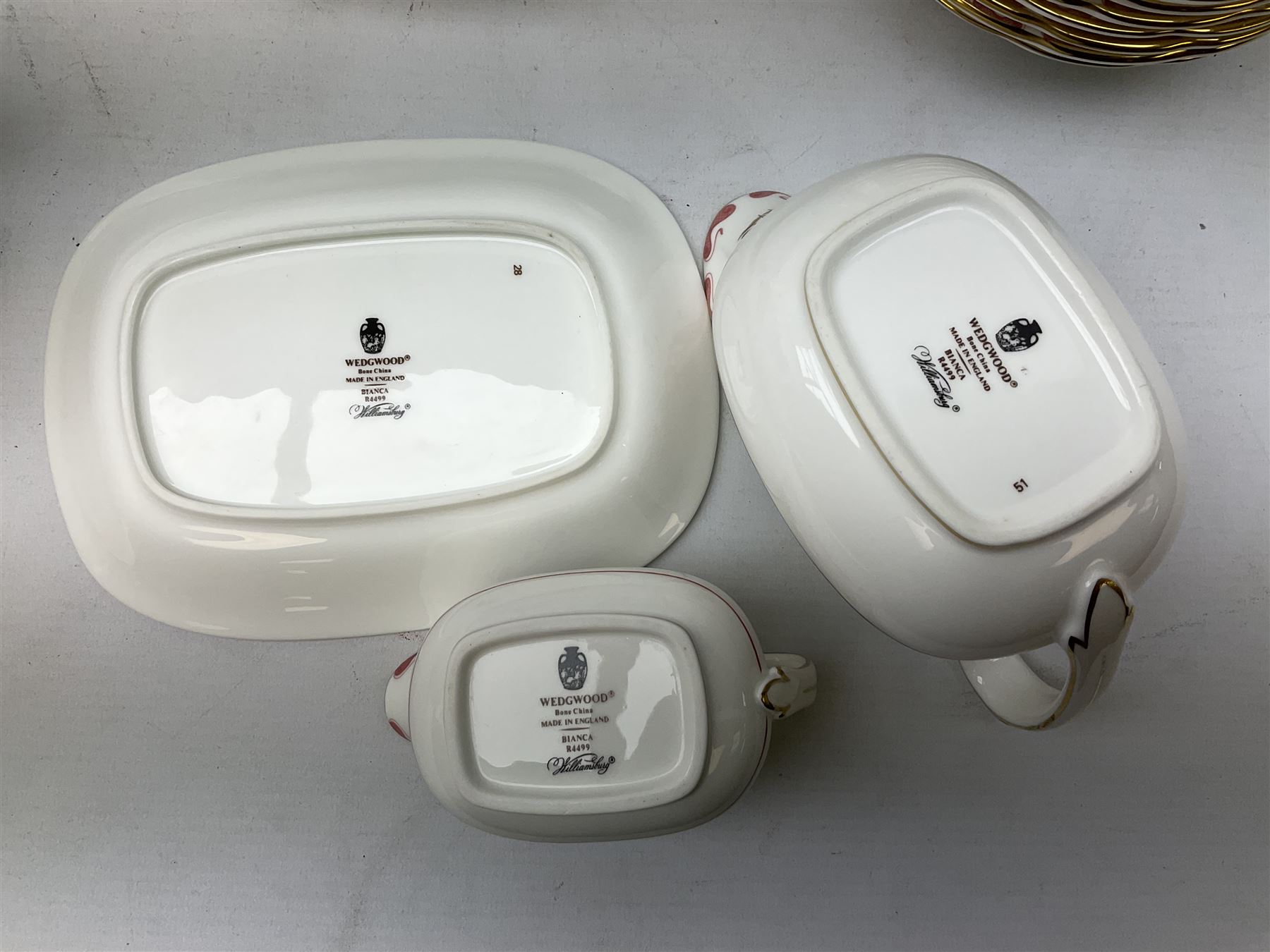 Wedgwood dinner service decorated in the 'Bianca' pattern, to include eight dinner plates, eight bowls, eight side plates, eight twin handled souo bowls, eight soup bowl saucers, eight teacups, eight teacup saucers, six dessert plates and two larger, two twin handled lidded tureens, milk jug, two sauce boats, salt and pepper shakers, oval serving  plate, twin handled sandwich plate, covered sucrier, small rectangular dish and two small circular dishes, all with printed stamp mark beneath