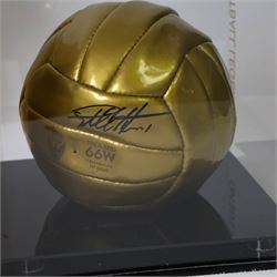 Limited edition football signed by Geoff Hurst to commemorate 50 years since England won the Football World Cup in 1966, a gold coloured football signed in black marker pen to one side, the ball stamped England 66W Celebrating 50 Years, contained within a Perspex display case, with certificate of authenticity from Northern Promotions