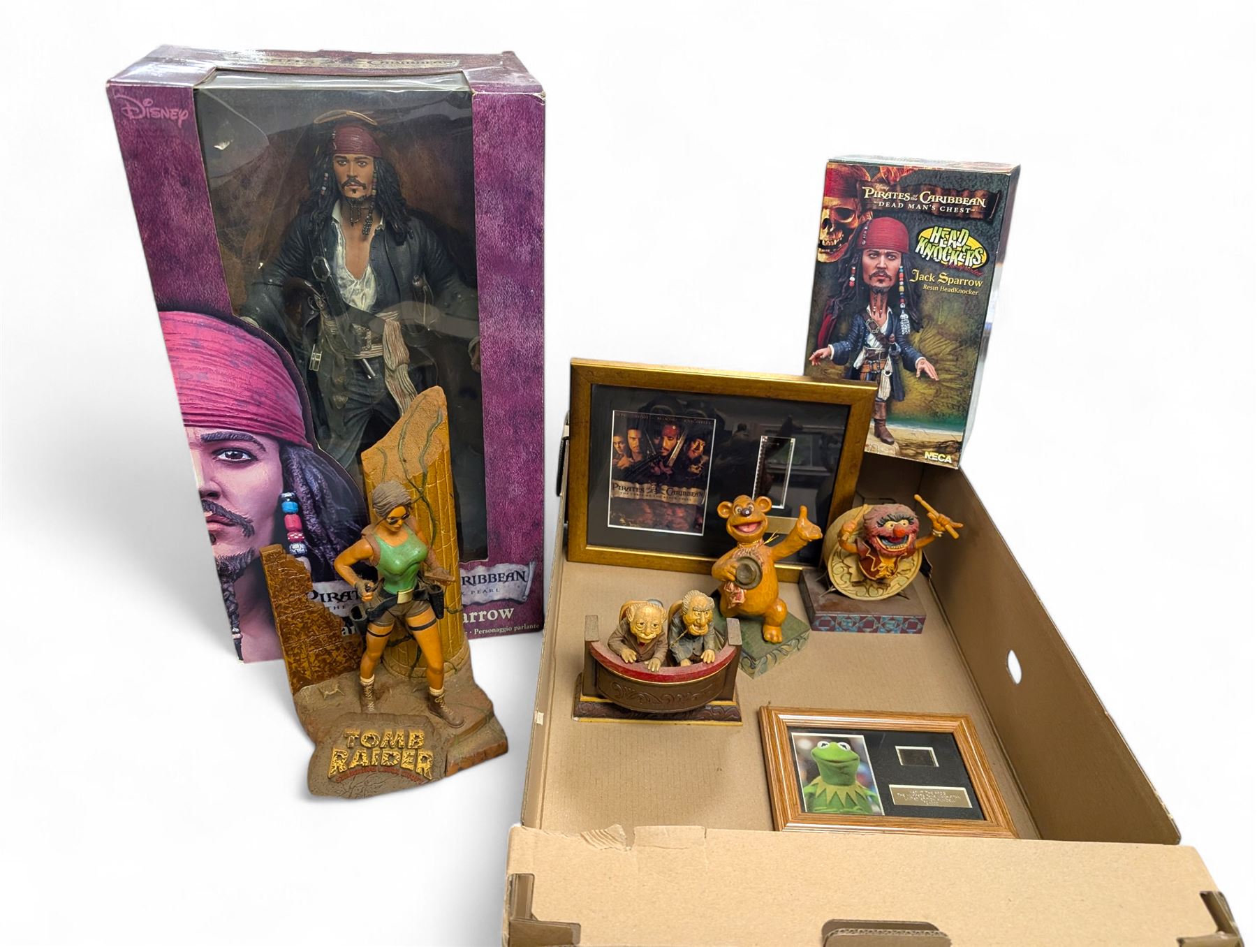 Collection of Disney and similar figures and memorabilia, including Pirates of the Caribbean Capt Jack Sparrow talking figure and NECA toys Jack Sparrow Head Knocker, three Disney showcase figures, Kermit the Frog framed film cell and Tomb Raider figure