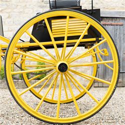 J. W. Thompson Dog Cart

A black and yellow painted two wheeled dog cart with elevated upholstered seat for two, buttoned black leather cushions, high back rail, folding front footboard, louvred sides, side steps, rear drop-down tailboard with chain stays, internal storage compartment, wooden spoked wheels, rubber tyres and shafts for a single horse. The wheel hubs are marked J W Thompson

Dimensions:
Overall length: 366 cm
Width: 160 cm
Height: 190 cm

Wheel Diameter:
Wheels: 139 cm

Seating:
Driver and passenger: 2