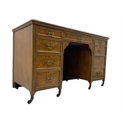 Late 19th century burr oak writing desk, fitted with nine drawers, inset writing surface, enamel castors