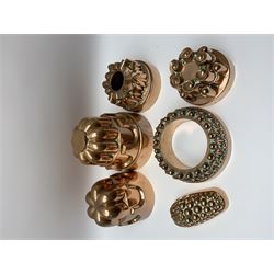 Six Victorian copper jelly moulds, five examples of castle type form, one example modelled as a bunch of grapes, largest H21cm