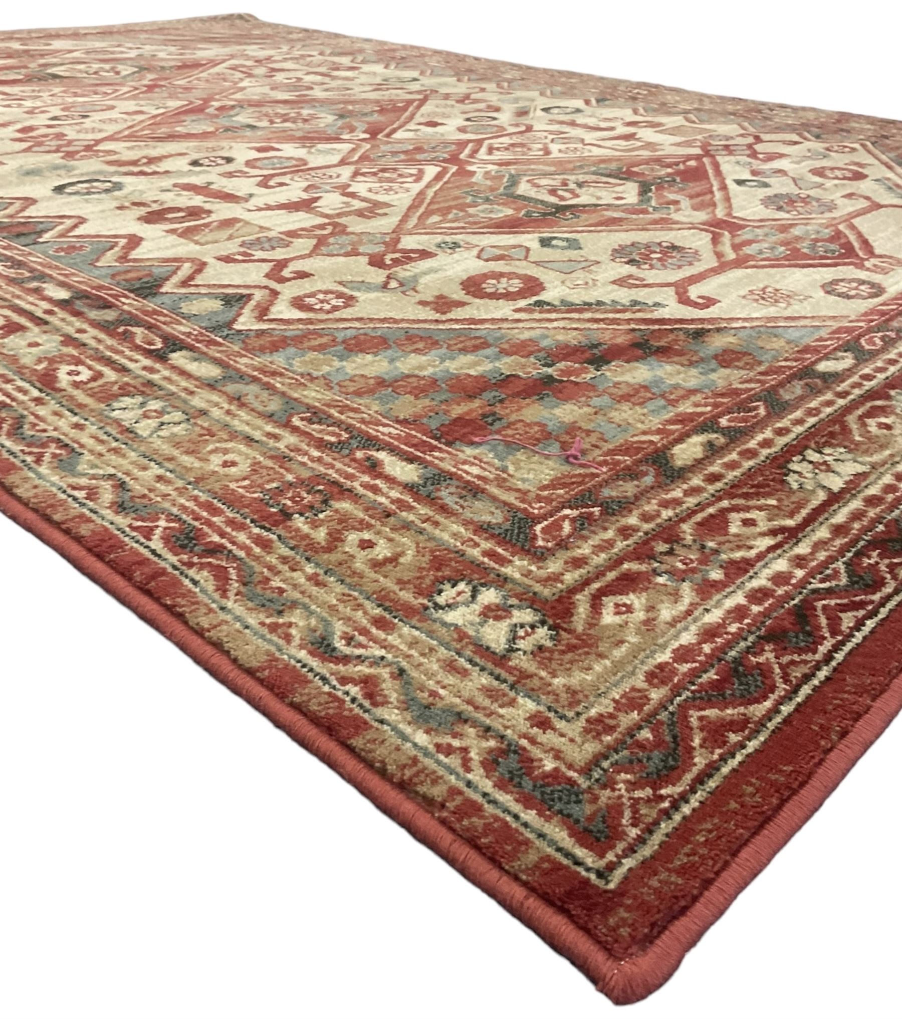 Persian design red ground rug, the field decorated with three interlinked lozenges and small stylised plant motifs, the multiple band border decorated with Boteh and floral motifs