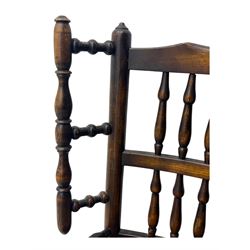 Early 19th century ash armchair, the back with winged spindles extending from a shaped top rail, above a splat of two rows of vertical spindles, with curved arms and a rush seat, raised on turned supports united by double stretchers terminating in castors