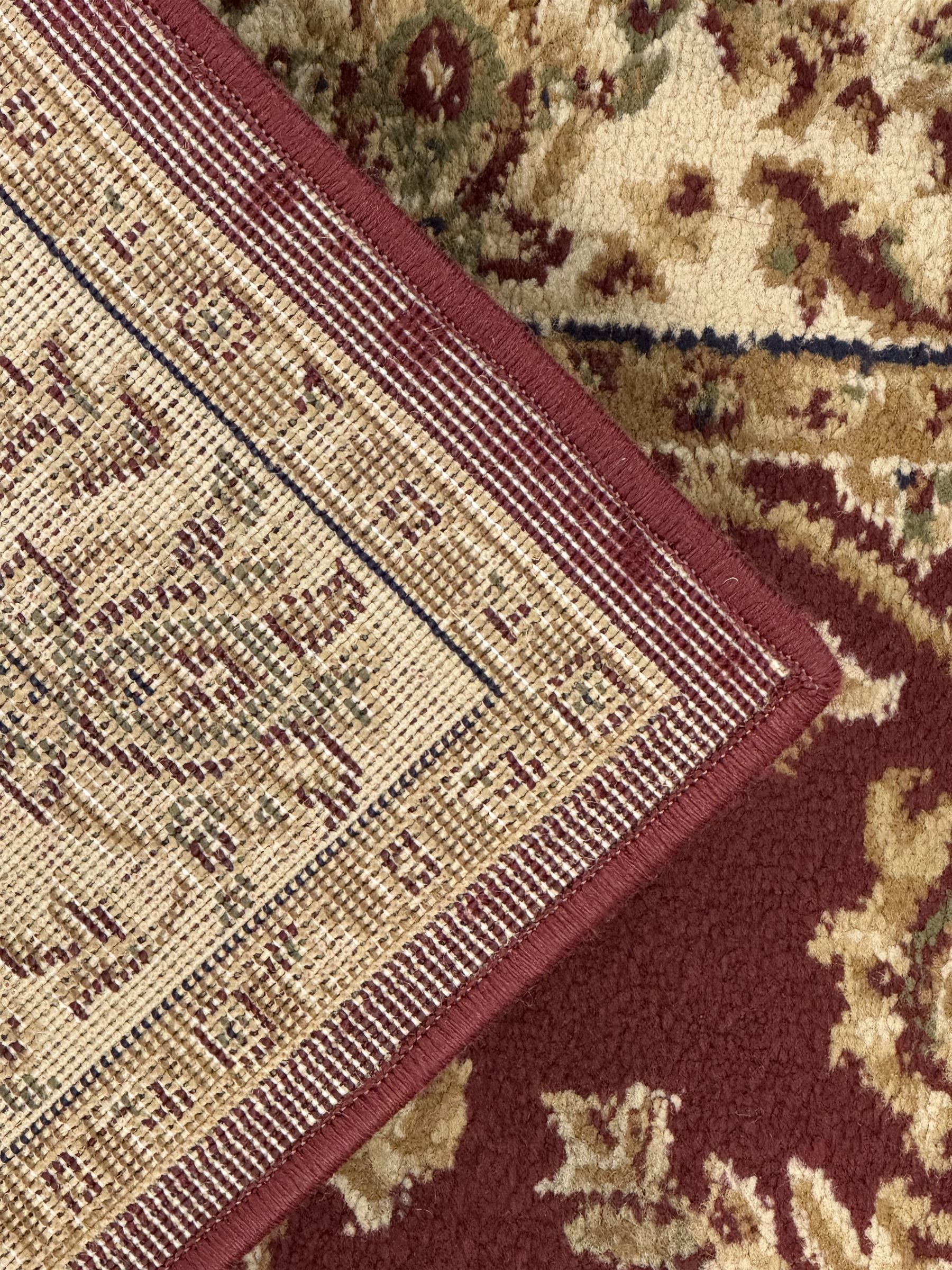 Contemporary Dunelm 'Legacy' ground rug, the field decorated with symmetrical scrolling foliate and floral motifs, bordered by an ivory band with repeating floral designs interspersed with leafy branches, inner guard stripe with fine linear patterning
