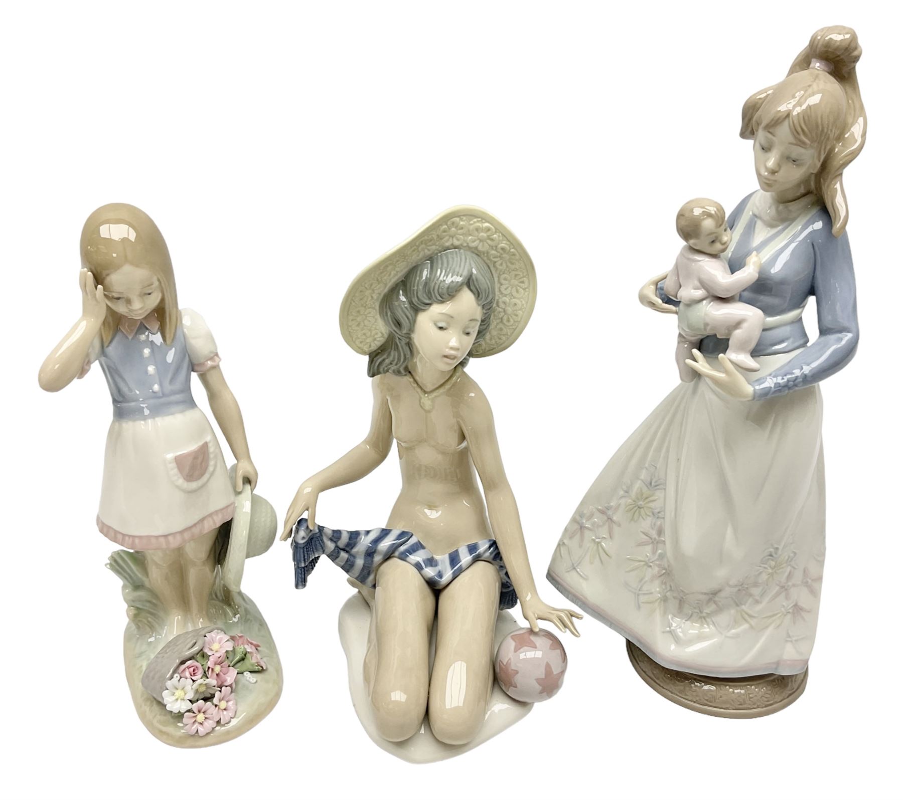 Three Lladro figures, comprising Modern Mother no 5873, Dropping the Flowers no 1285 and On the Beach no 1481, all with original boxes, largest example H30cm