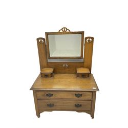 Arts & Crafts style oak low dressing table, raised swing mirror with pierced supports, fitted with two small trinket drawers and two long drawers