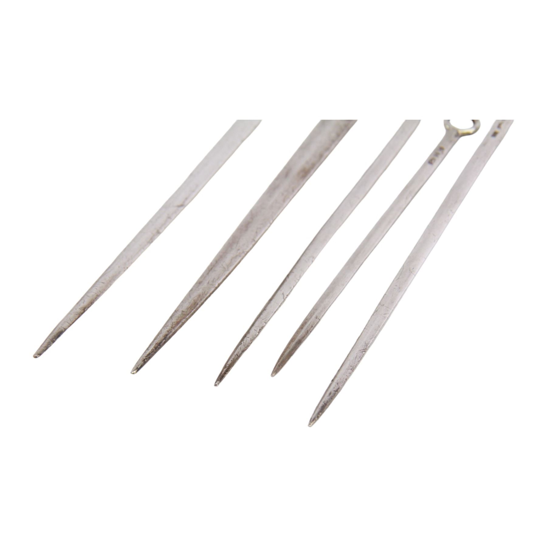 Two George III silver meat skewers, the first example with shell mounted ring terminal, hallmarked Philip Roker III, London 1765, L31cm, the second with ring terminal, hallmarked Thomas Wilkes Barker, London 1810, L32.5cm, together with three George III silver poultry skewers, one example hallmarked Solomon Hougham, London, date letter worn, possibly 1804/1806, and two hallmarked London 1804, no visible makers marks, longest poultry skewer L20cm, smallest L15.5cm, bearing Christie's lot label, (5)

Provenance: Lot 225, portrait Miniatures, Objects of Vertu and Silver, Christie's, 22nd February 2005