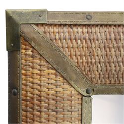 Rustic wall mirror with brass, leather and rattan frame, enclosing a bevelled plate