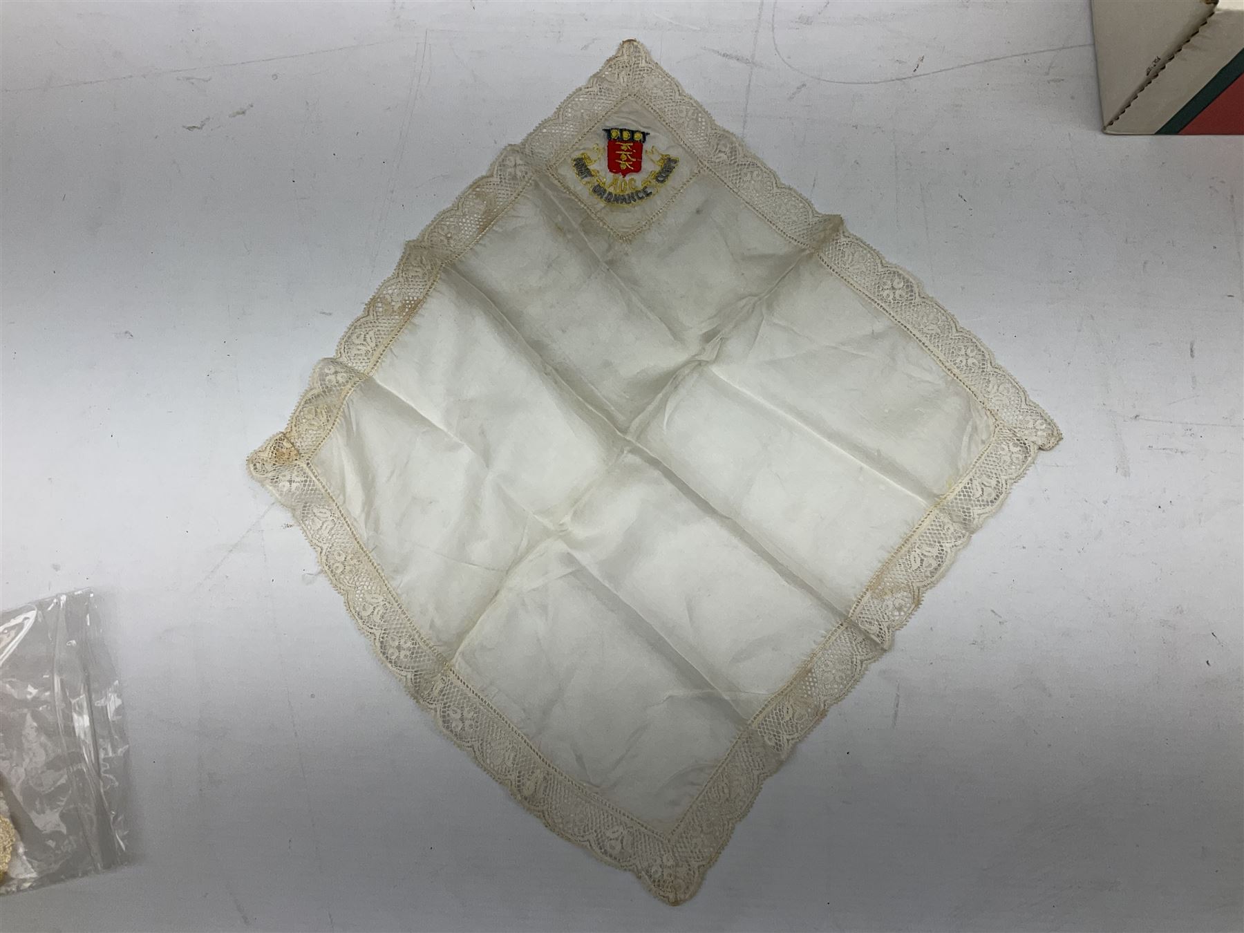 Three WW1 embroidered silk handkerchiefs including RAF & RN; trench art brass napkin ring inscribed 'Arras' and miniature peaked cap with inset 1914 penny; small quantity of cap badges and pips; four reference books on medals and badges etc