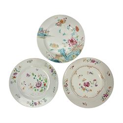 Three 18th century Chinese Famille Rose plates, the first example enamelled with blossoming peonies, rockwork and fence, the other two examples of similar design, decorated with blossoming peonies and sprigs within shaped inner borders, each approximately D23cm