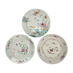  Three 18th century Chinese Famille Rose plates, the first example enamelled with blossoming peonies, rockwork and fence, the other two examples of similar design, decorated with blossoming peonies and sprigs within shaped inner borders, each approximately D23cm