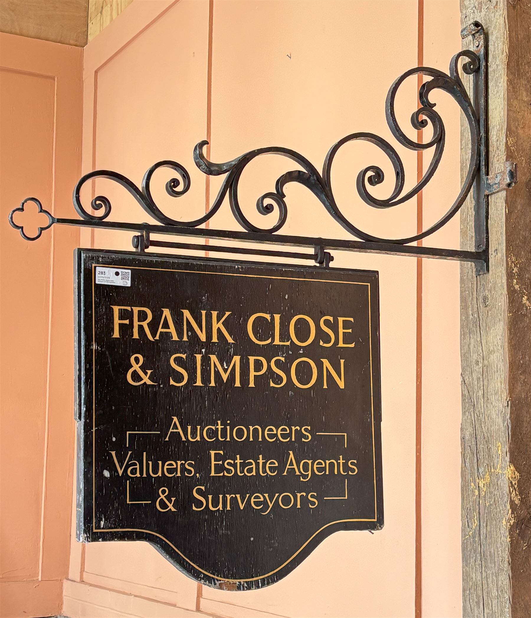 Wrought iron hanging sign, the bracket of scrolling floral design supporting a painted sign for Frank, Close & Simpson Auctioneers. L104cm - COLLECTION BY APPOINTMENT FROM: The White House, Thirsk Road, Easingwold, York, YO61 3NF - CALL 01723 507111 TO ARRANGE