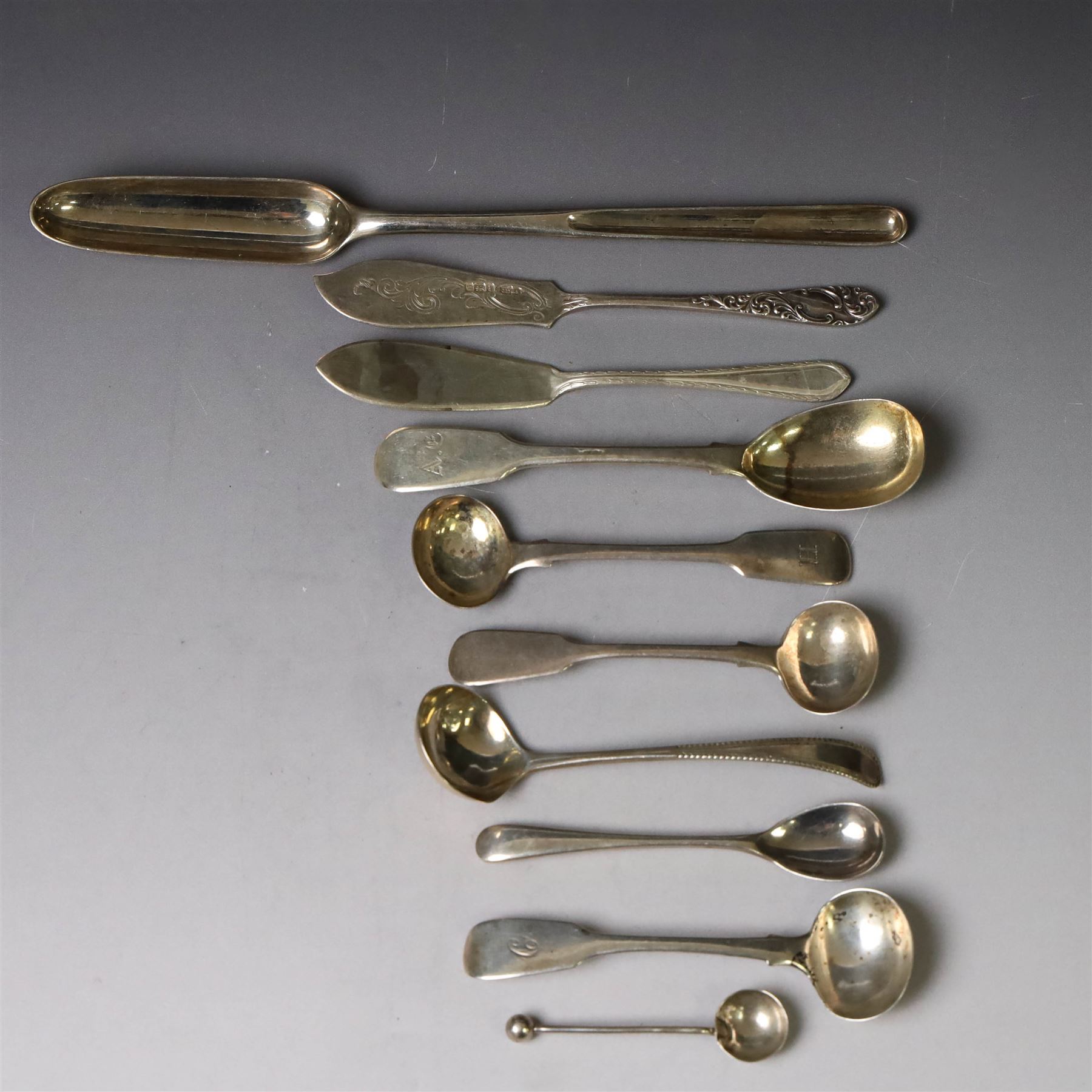 George III silver marrow scoop, hallmarked London 1767, makers mark indistinct, together with a collection of silver condiment spoons and butter knives, all hallmarked