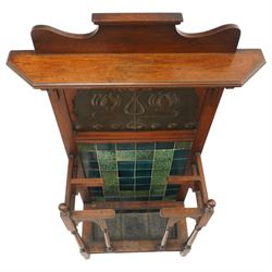 Shapland & Petter of Barnstaple - Arts & Crafts mahogany tile-backed umbrella or stick hall-stand, model no.114, the shaped back with single shelf over an Art Nouveau embossed patinated copper panel and turquoise tiled back, with turned supports and dividers over inset metal drip tray

Notes: A comparable Shapland & Petter stick stand of this model is recorded in Daryl Bennett, Shapland & Petter Ltd of Barnstaple, Museum of Barnstaple and North Devon, p.84, cat. no.5.37, and the model is also listed in Bennett, Liberty’s Furniture 1875-1915, p.298, cat. no.8.6. Examples of this model are known to have been retailed by Liberty & Co.