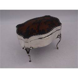 Early 20th century silver mounted jewellery casket, the slightly domed hinged cover set with a tortoiseshell panel, with a embossed floral border, opening to reveal a pleated silk lined interior, upon four cabriole legs, hallmarked Charles Boyton & Son Ltd, London 1913, H10cm