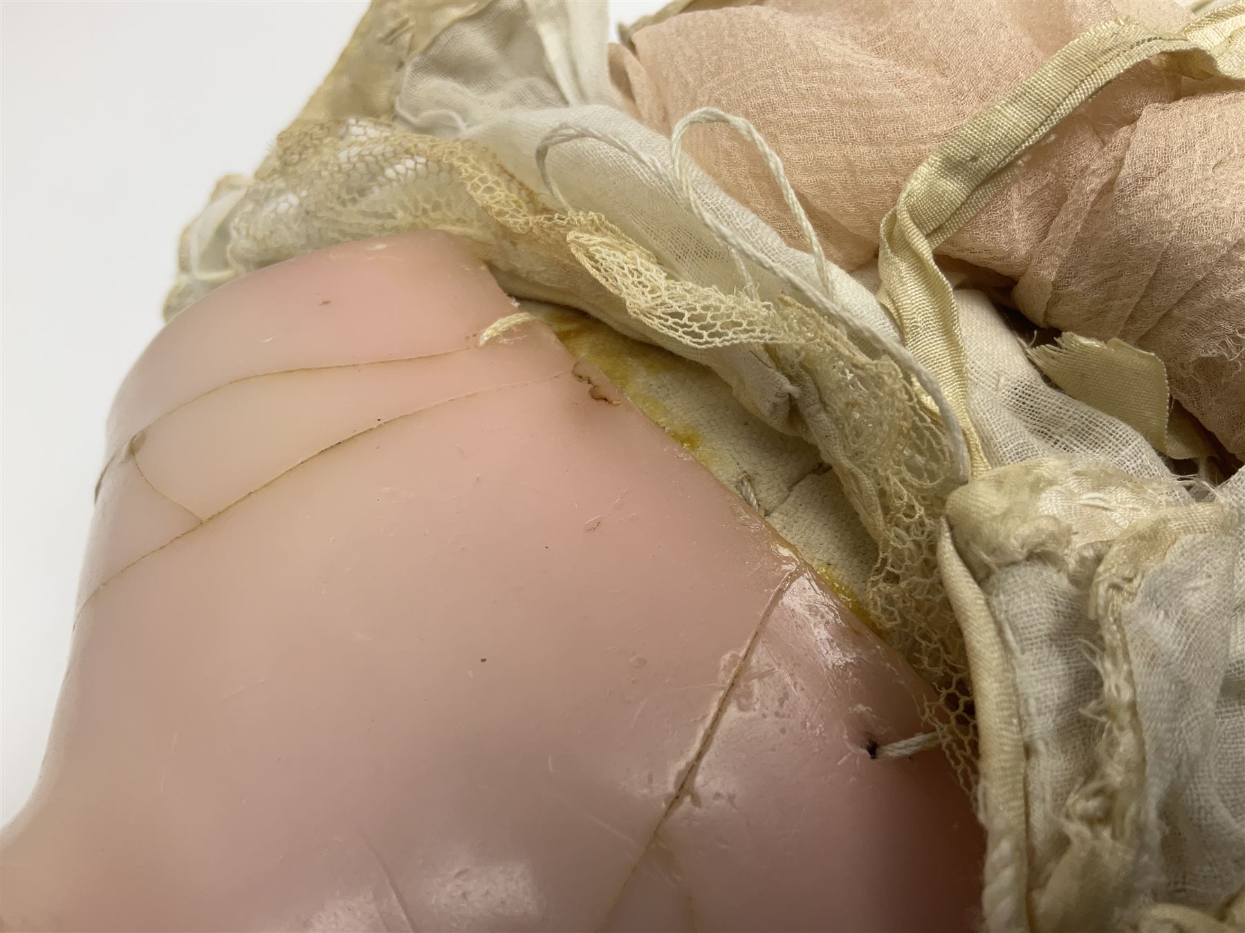 Victorian wax shoulder head doll with pale complexion, applied hair, inset glass eyes and fabric covered jointed body with kid leather lower arms; white linen dress and undergarments H50cm