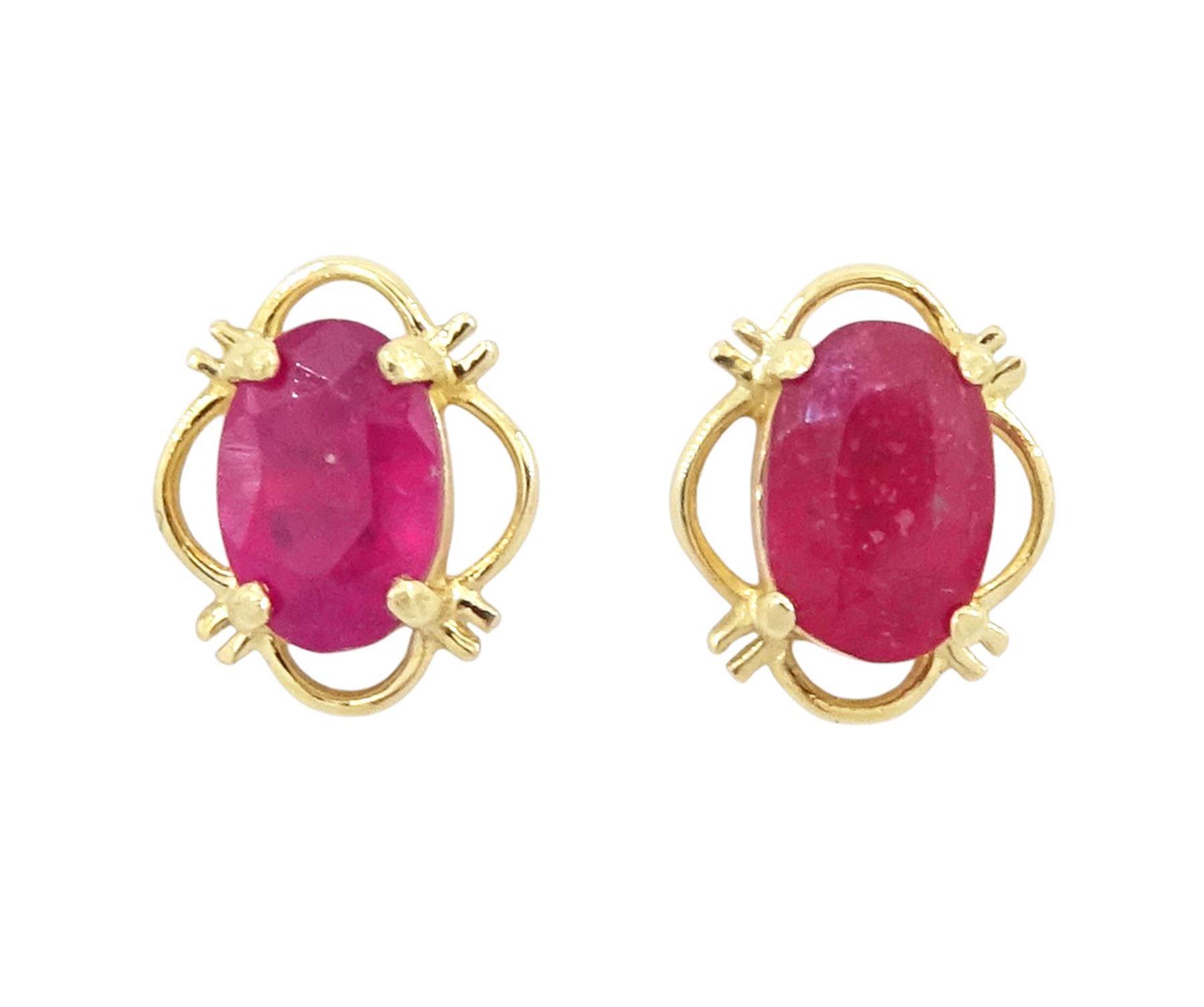 Pair of 9ct gold oval cut ruby stud earrings, stamped