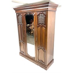 Late Victorian wardrobe, projecting dentil cornice, two carved doors flanking central shaped and bevelled mirror door, fitted interior including shelving and drawers, shaped plinth support