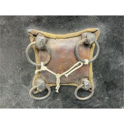 Indian black lacquered hide shield/dhal, of circular convex form with strongly outward-turned brim, fitted at its centre with four metal bosses, each of hemispherical form, with traces of silvered foliate decoration, the bosses corresponding on the inside with four iron rings for enarmes D49cm