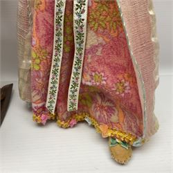 Anna Meszaros Hungary - three hand made needlework figurines - 'The Cobbler' as a child seated in a wooden rocking chair working on a removed boot H28cm; young girl in a long floral dress standing playing a harp H35cm; and young girl wearing a blue tabard standing playing a lute (3) Auctioneer's Note: Anna Meszaros came to England from her native Hungary in 1959 to marry an English businessman she met while demonstrating her art at the 1958 Brussels Exhibition. Shortly before she left for England she was awarded the title of Folk Artist Master by the Hungarian Government. Anna was a gifted painter of mainly portraits and sculptress before starting to make her figurines which are completely hand made and unique, each with a character and expression of its own. The hands, feet and face are sculptured by layering the material and pulling the features into place with needle and thread. She died in Hull in 1998.  