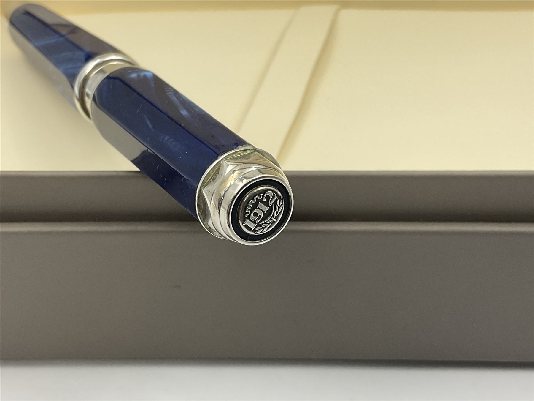 Montegrappa Emblema ball pen, the blue pearl marbled barrel of octagonal form with silver mounts and terminal with 1912 emblem, stamped 925 and clip with roller, in box, L13.5cm