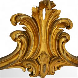 Large Victorian gilt wood overmantle mirror, shaped cresting rail with curled acanthus leaf pediment, the corners decorated with foliate C-scrolls and flower heads, curled foliage lower corner brackets, plain mirror plate 