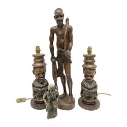 Pair of 20th century carved wood table lamp with African busts and figures, together with a carved wooden figure and soapstone figure, lamps H44cm