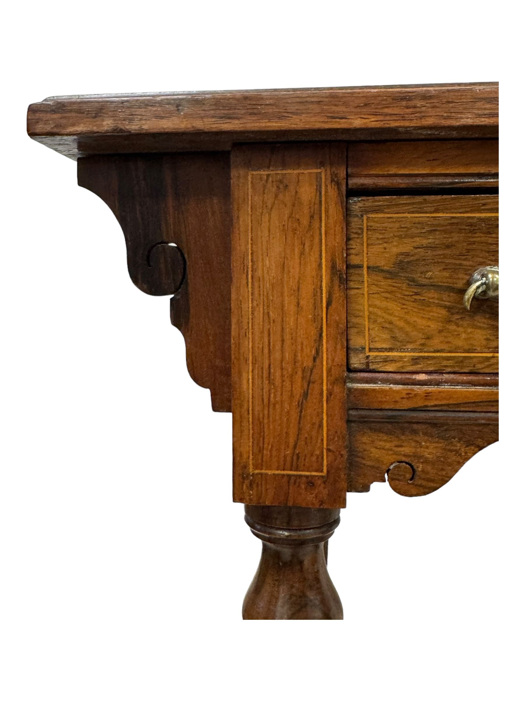 Late Victorian walnut writing table, rectangular leather-inset top surmounted by a brass gallery, fitted with a single frieze drawer, raised on turned tapering supports with lower undertier and ceramic castors