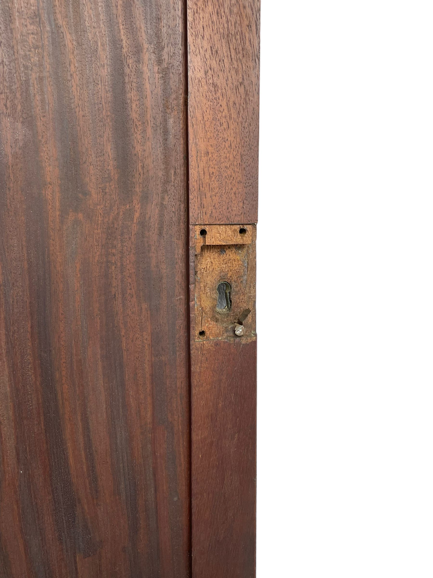 George III mahogany Gentleman's linen press, the projecting cornice over two panelled cupboard doors enclosing three sliding trays, the base fitted with two short over three long graduating cock-beaded drawers, lower moulded edge over bracket feet