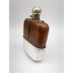 A large glass hip flask with silver plated removable base/cup, silver plated screw threaded cover, and leather clad upper section, H7.5cm. 