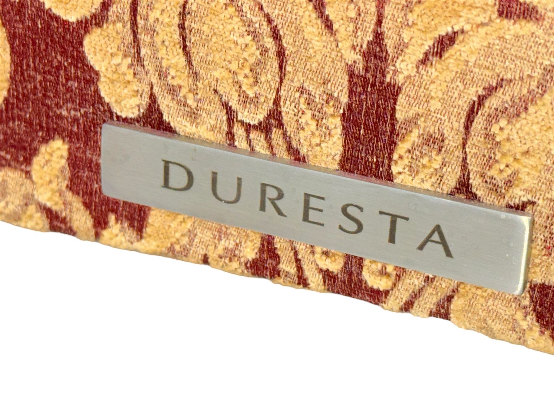 Duresta - pair of Grande three-seat sofas, traditional shaped with rolled arms and upholstered loose cushions, in red ground fabric with raised gold foliate pattern, on turned feet with brass castors 