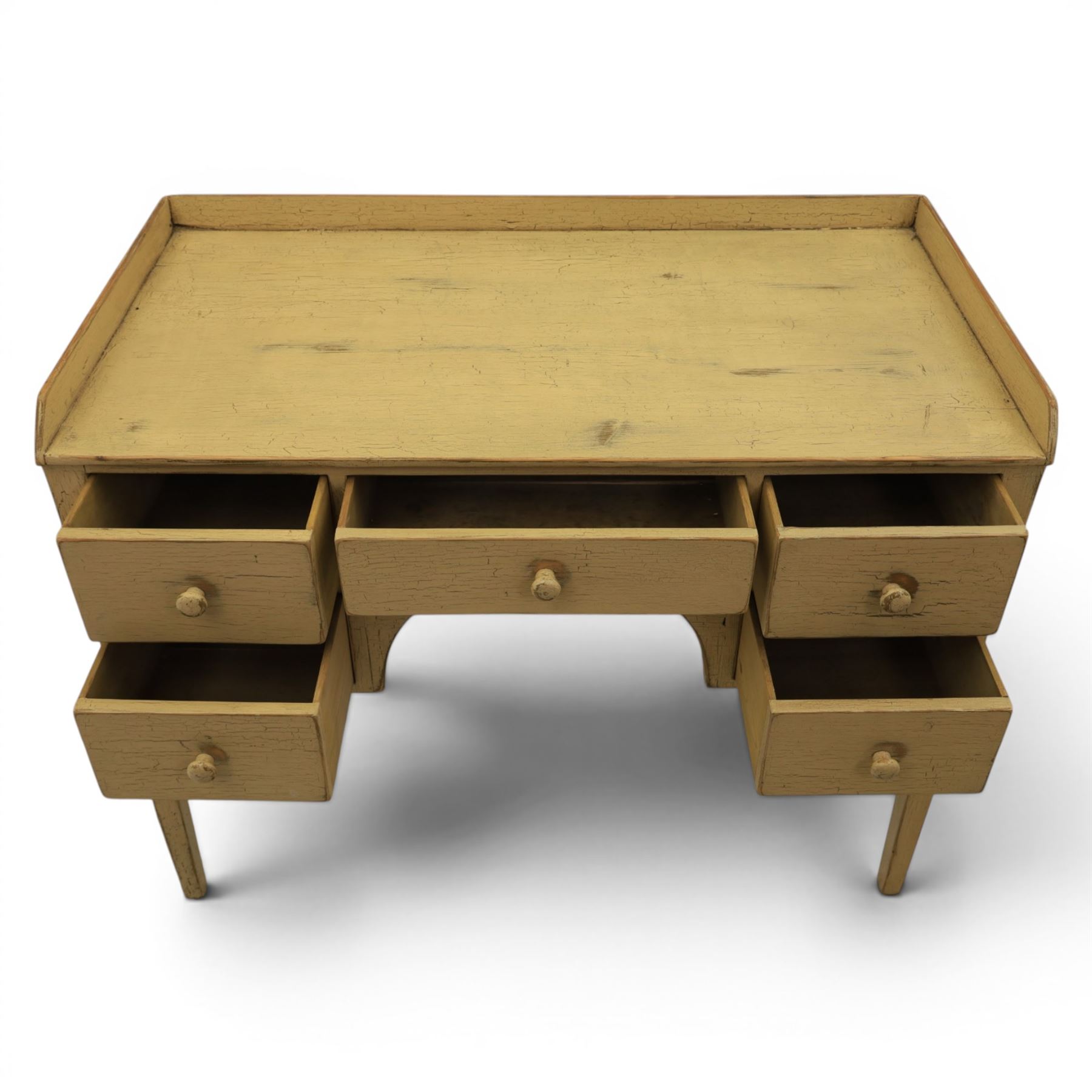 Pine country writing desk, rustic cream paint finish, galleried top over a central drawer flanked by two drawers, tapered square supports