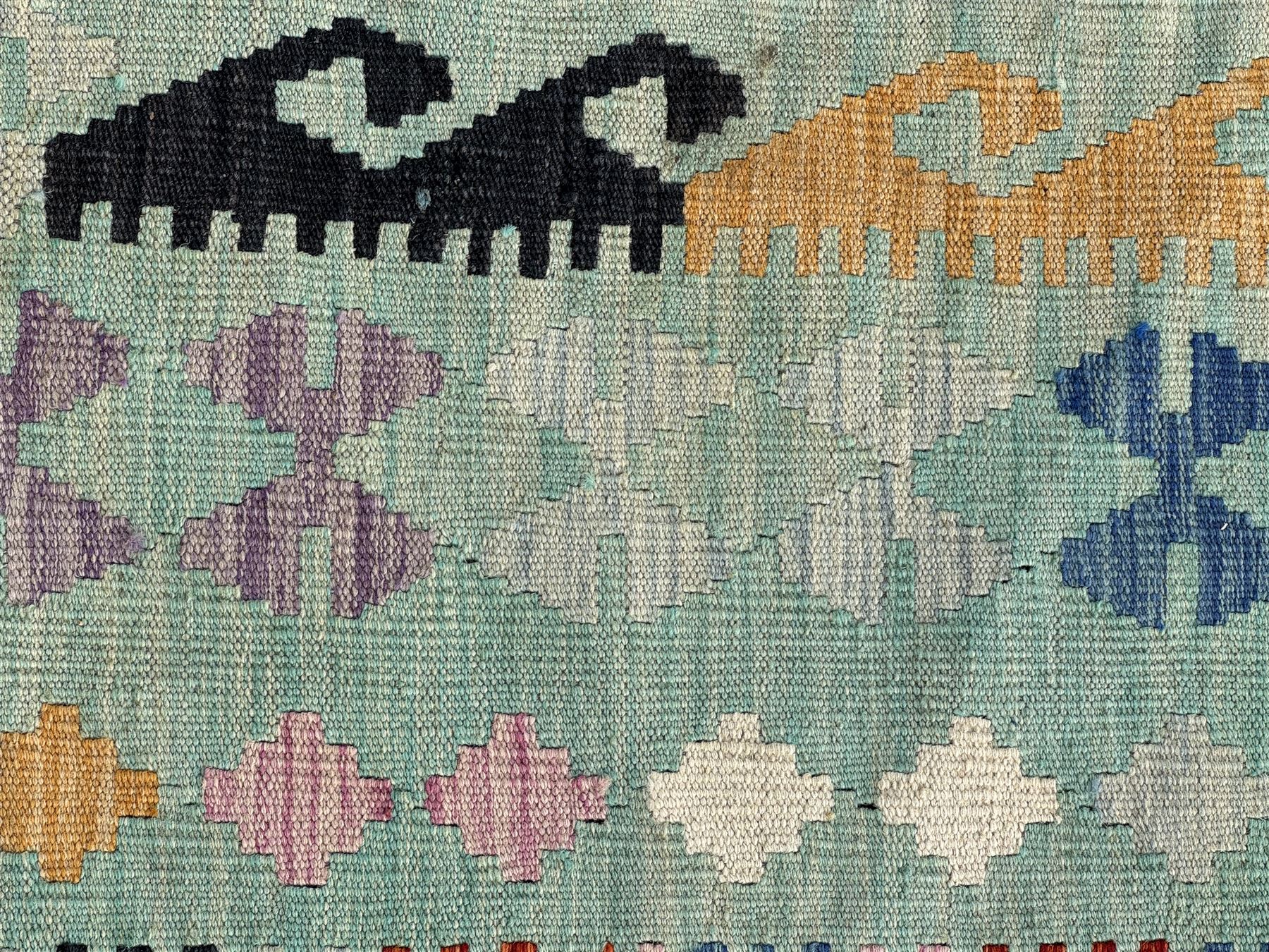 Kilim pastel ground rug, the field decorated with repeating multicoloured geometric diamond motifs, enclosed within matching geometric borders