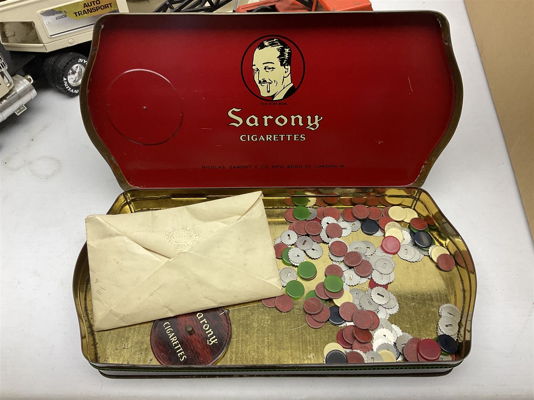 American Nylint large scale tin-plate car transporter L59cm carrying a Testor Toys plastic car; Tonka tin-plate mobile crane; boxed Sarony Cigarettes tin-plate roulette game with rules; and Japanese style tin-plate box, the lid inset with a revolving poker dice game (4)