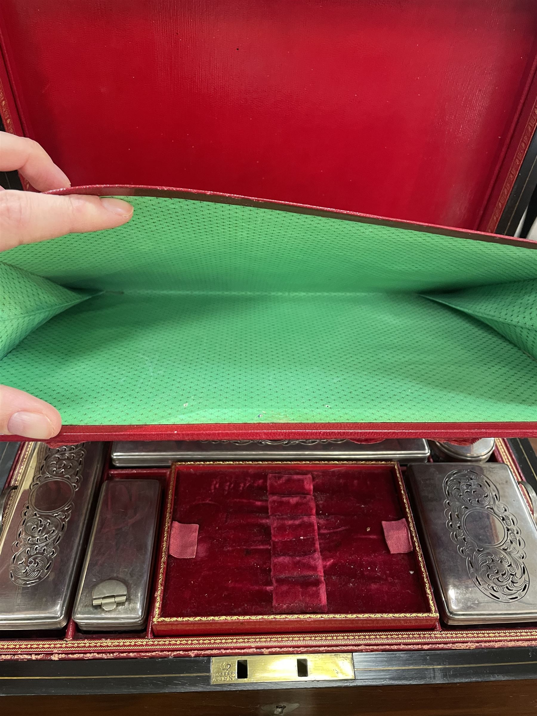  Victorian brass inlaid rosewood dressing table box, retailed by F.L. Hausburg, Liverpool, the lid centred by a brass cartouche, opening to reveal letter store to lid underside, above a fitted interior, with ten mounted cut glass jars, bottles and manicure set, within lift out leather trays, above jewellery drawer, with key, H17cm D24cm