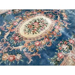 Large Chinese blue ground woollen carpet, overall floral design, central oval medallion surrounded by scrolling floral decoration, wide border with decorated with floral bouquets 