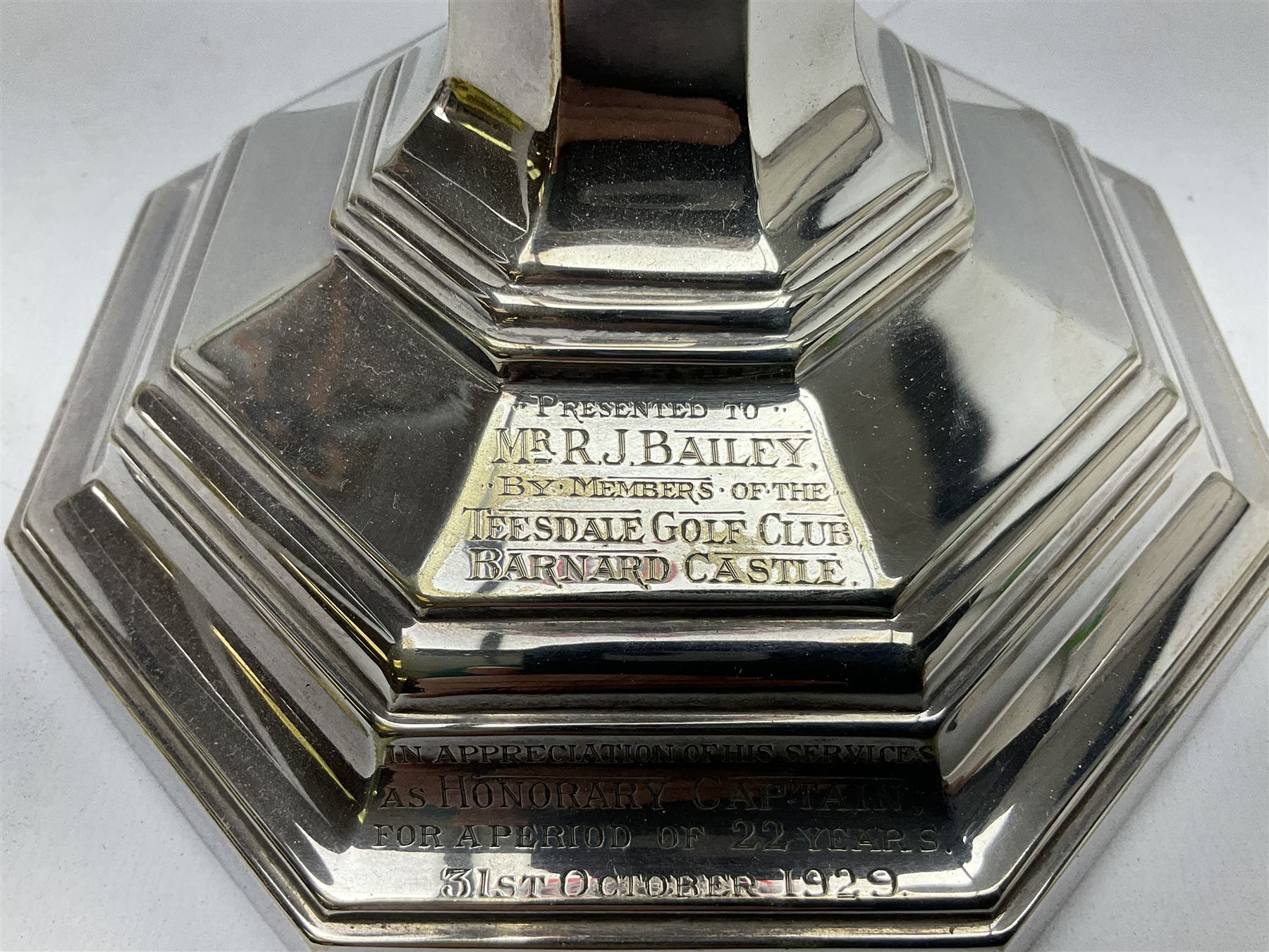 20th century Hawksworth, Eyre & Co silver plated oil lamp, the octagonal stepped base with engraved dedication, leading to an octagonal column supporting a faceted clear glass reservoir, Hinks Duplex burner, clear glass chimney, and cranberry glass shade, overall H71.5cm