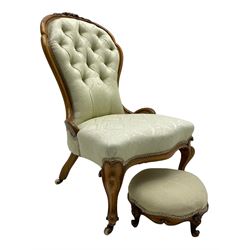 Victorian walnut framed nursing chair, the cresting rail decorated with carved applied flower heads and acanthus leaves, shaped back and sprung seat upholstered in buttoned ivory damask fabric, serpentine front over cartouche carved cabriole supports with ceramic castors (W57cm H92cm); with matched footstool, circular top over shaped moulded apron, on floral carved cabriole feet (W34cm) 