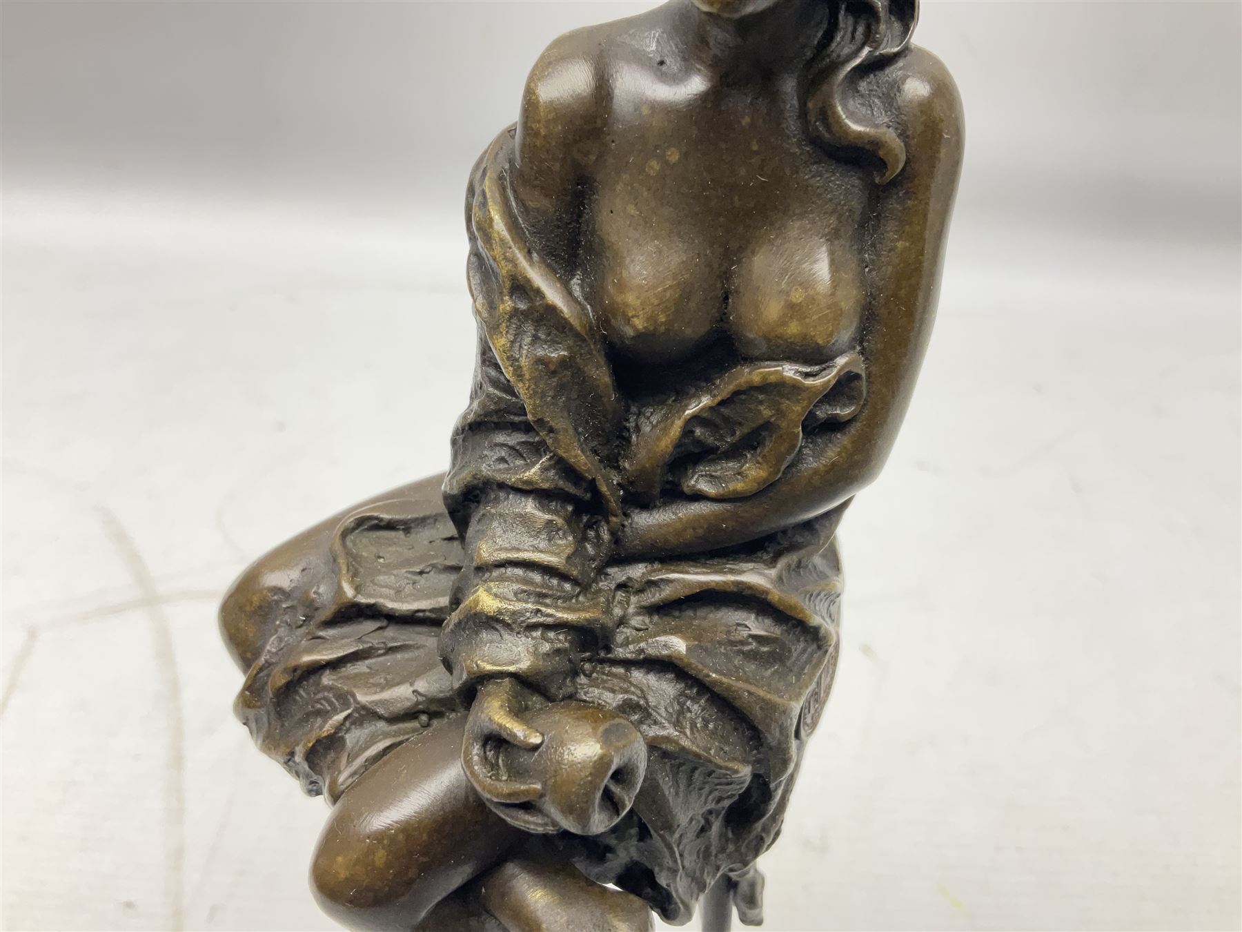 Art Deco style bronze modelled as a female figure seated upon a chair holding an apple, after 'Pierre Collinet', H28cm