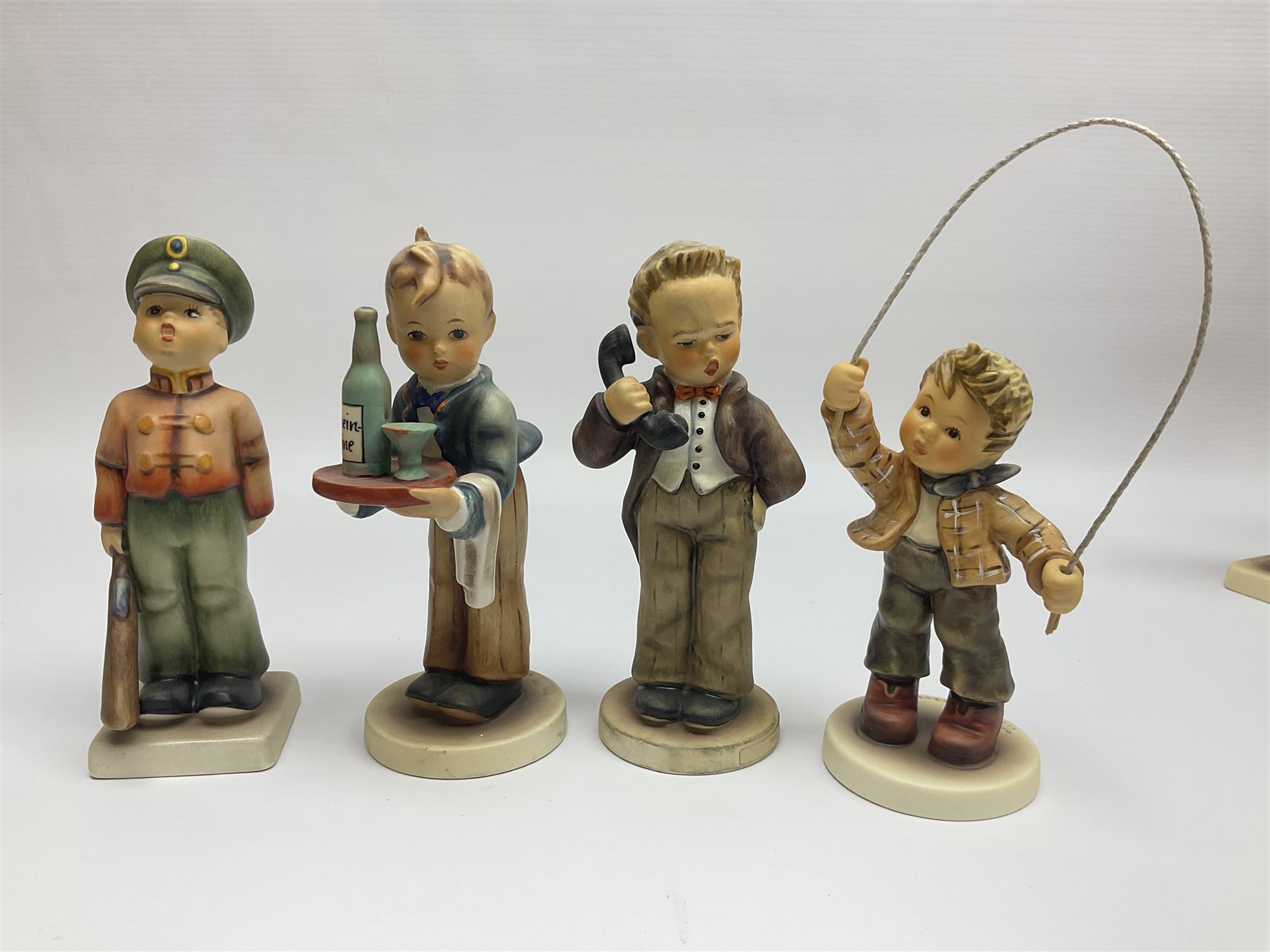 Thirty Hummel figures by Goebel, to include Saluting the Peacekeepers of Operation Joint Endeavor, on wooden plinth, Call to Glory, Celebrate with Song and Soldier Boy