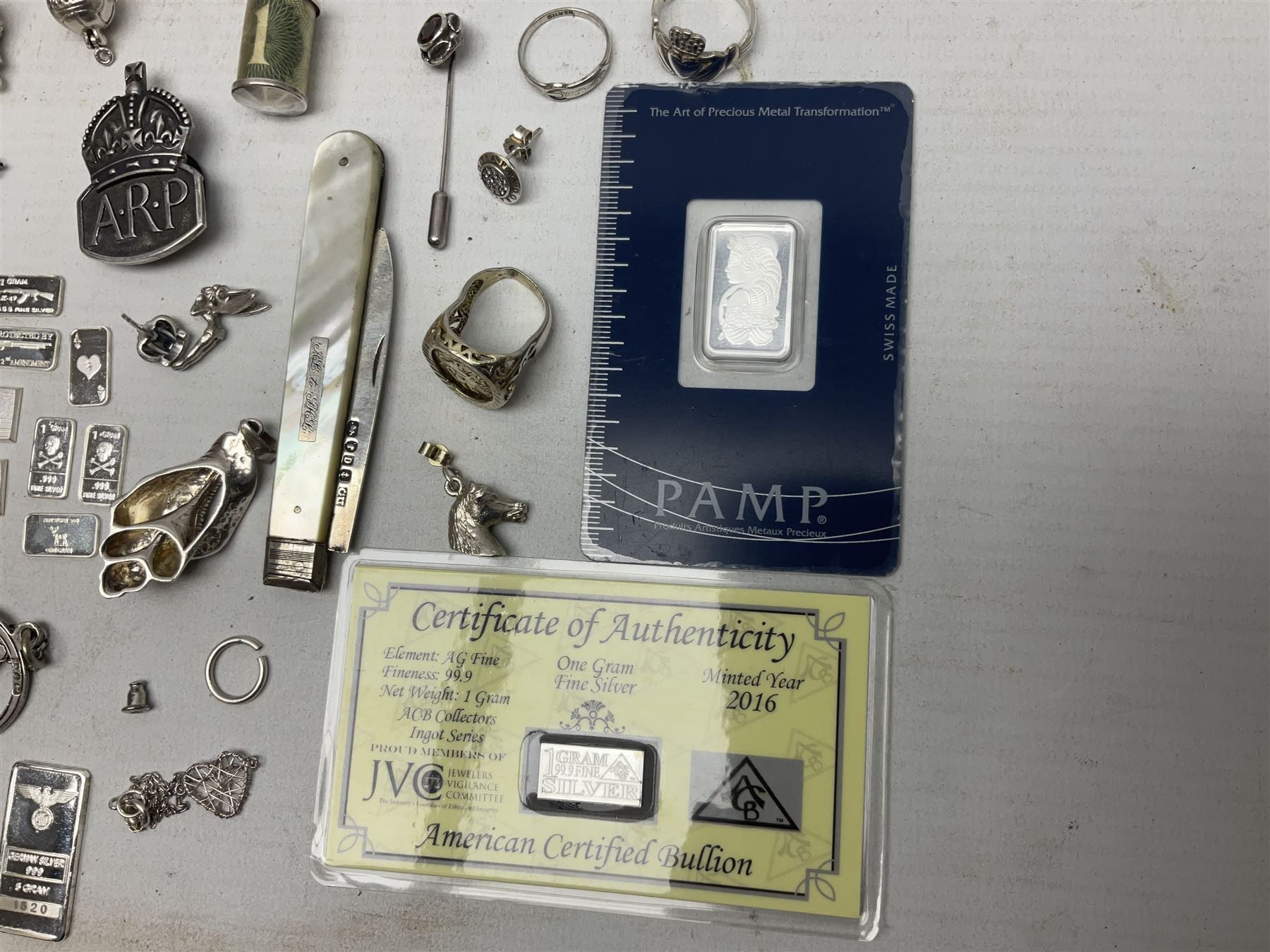 Silver mother of pearl handled fruit knife, silver jewellery including masonic pendant necklace, shell pendant, coin ring, Claddagh ring and charms etc, and a collection of ingots