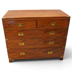 19th century figured mahogany military campaign chest of drawers in two sections, the rectangular top with brass-bound corners over two short and three long graduated drawers, each fitted with recessed brass campaign handles and escutcheons, the carcass with brass strapwork and carrying handles to the sides, raised on short bracket feet