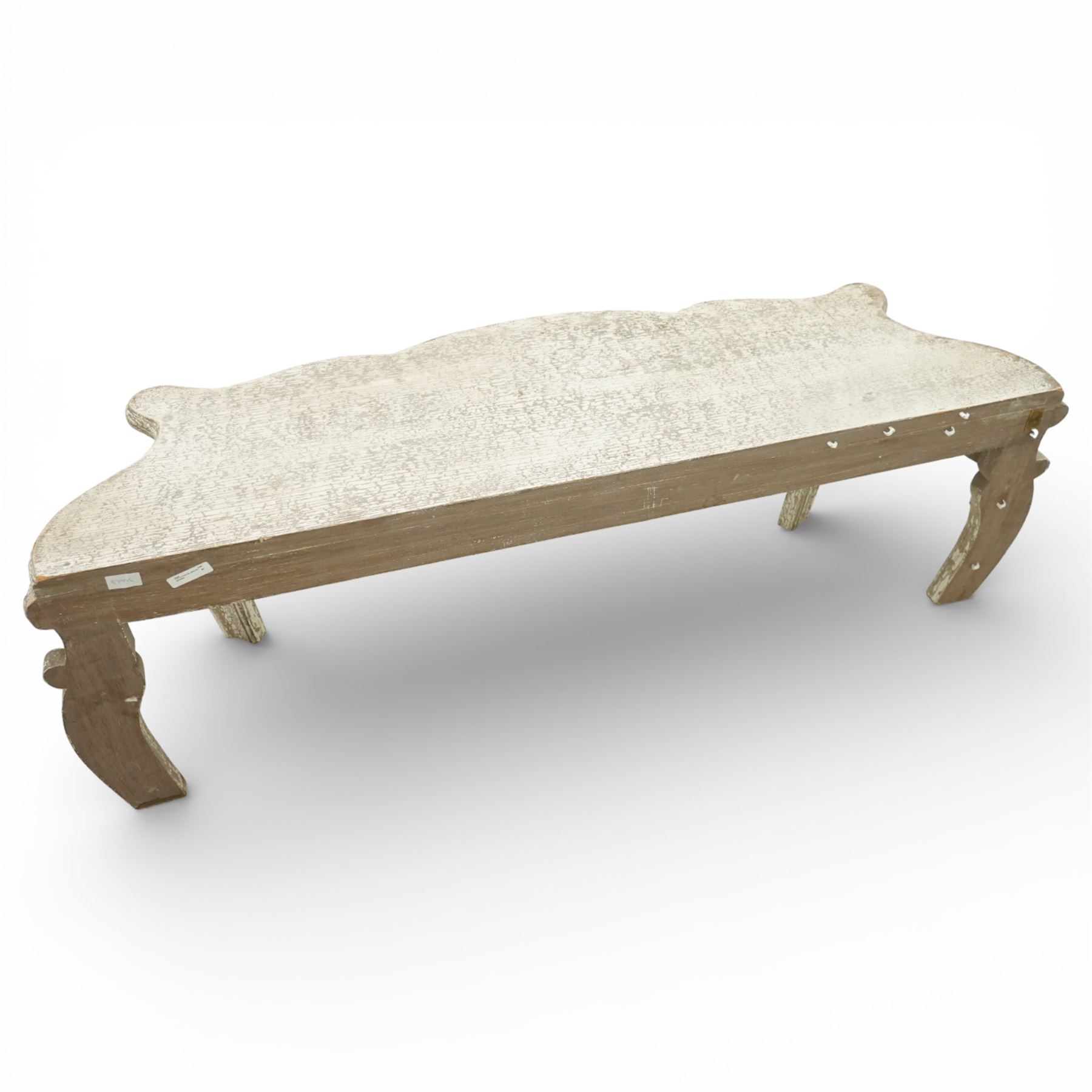 French style low console table, the shaped rectangular top with undulating outline and moulded edge, worn painted finish throughout, the frieze carved with flowing C-scrolls, shell and foliate detail centred by a floral reserve, on cabriole legs with carved knees and inward curving feet