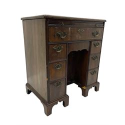 Georgian walnut kneehole desk, moulded rectangular top with book-matched veneers within crossbanding, fitted with slide over one long drawer, frieze drawer, six small drawers and recessed cupboard, raised on bracket feet