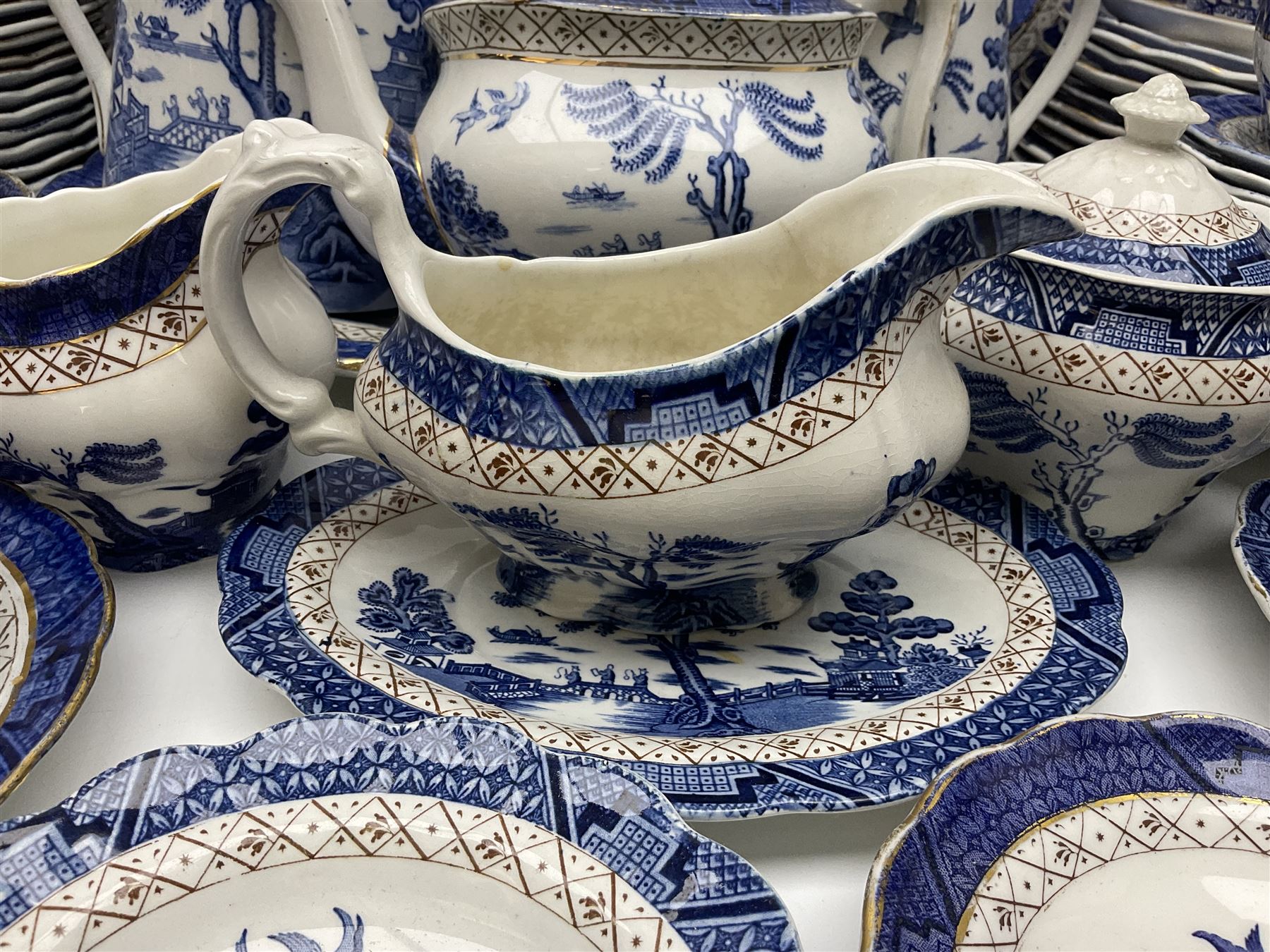Booths Real Old Willow pattern part tea and dinner service, to include two meat platters, cake stand, teapot, two jugs, sugar bowl, sauce boat, teacups and saucers and a collection of plates and bowls