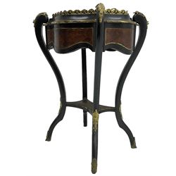 Late Victorian ebonised and amboyna wood jardinière planter, shaped form with removable lid inlaid with scrolling brass work and mounted by ornate cast gilt metal handles, the frieze rails inlaid with amboyna panels and brass stringing, on cabriole supports united by under-tier, decorated with cast gilt metal acanthus leaves and hooved feet caps