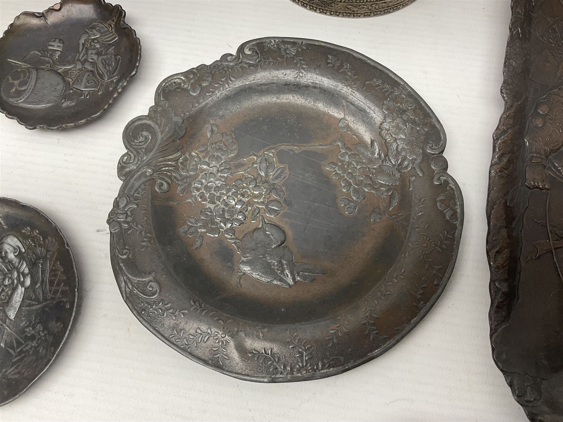 Brass sunfish ashtray, Chinese silver plated trinket box with mirror, bronzed matchbox cover and a collection of other Oriental bronzed embossed metal trays