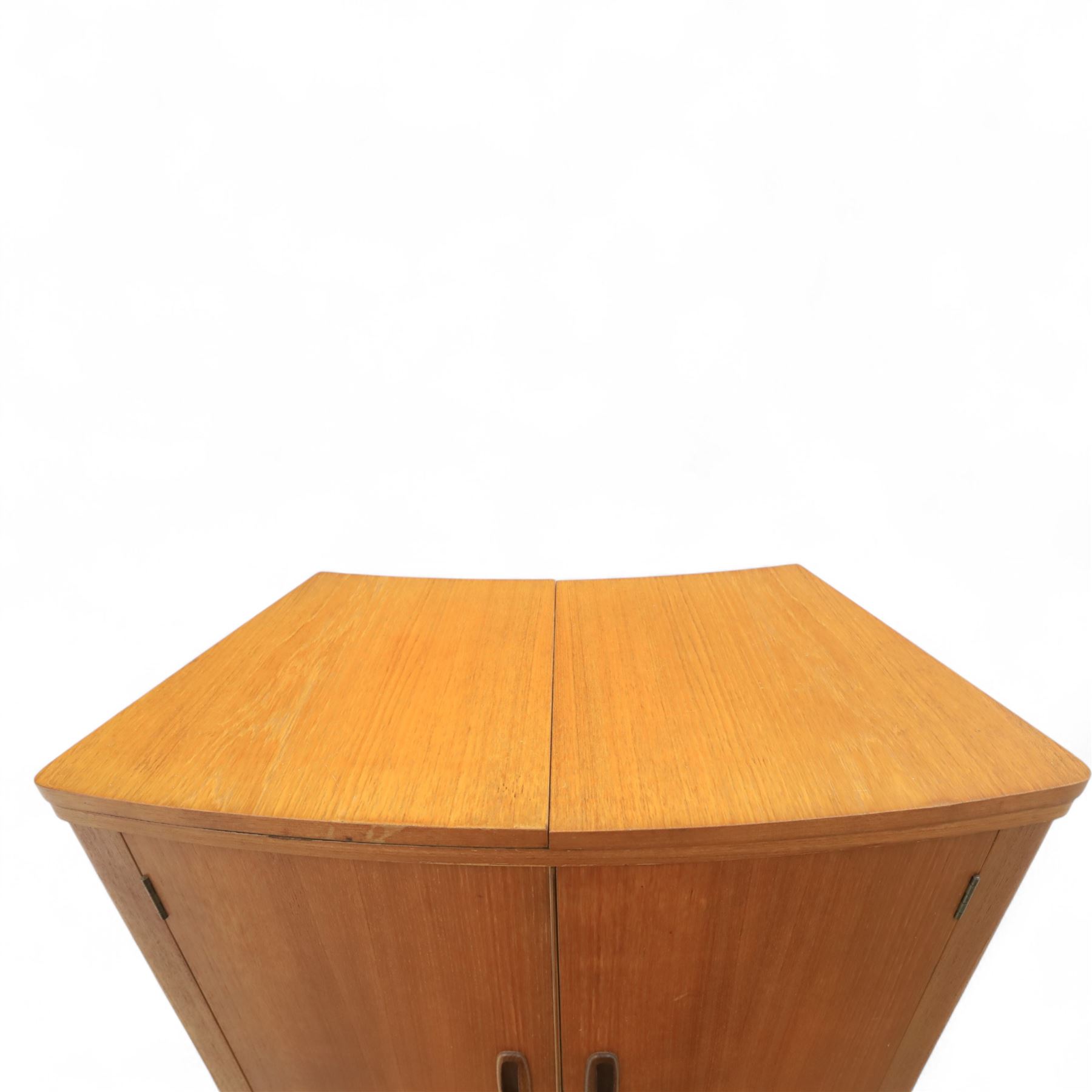 Turnbridge of London - Mid 20th century teak cocktail cabinet, with fold out top extending to 160cm, with twin doors revealing a shelved interior, the back with sliding glazed doors, raised on a recessed plinth base with castors